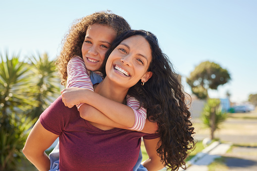 Happy mother and daughter hugging on a beautiful sunny day.